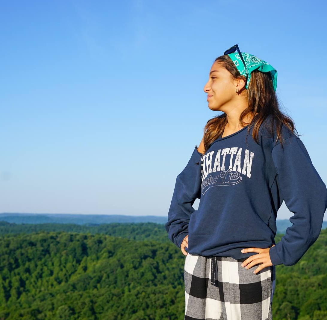 As she stands atop this mountain